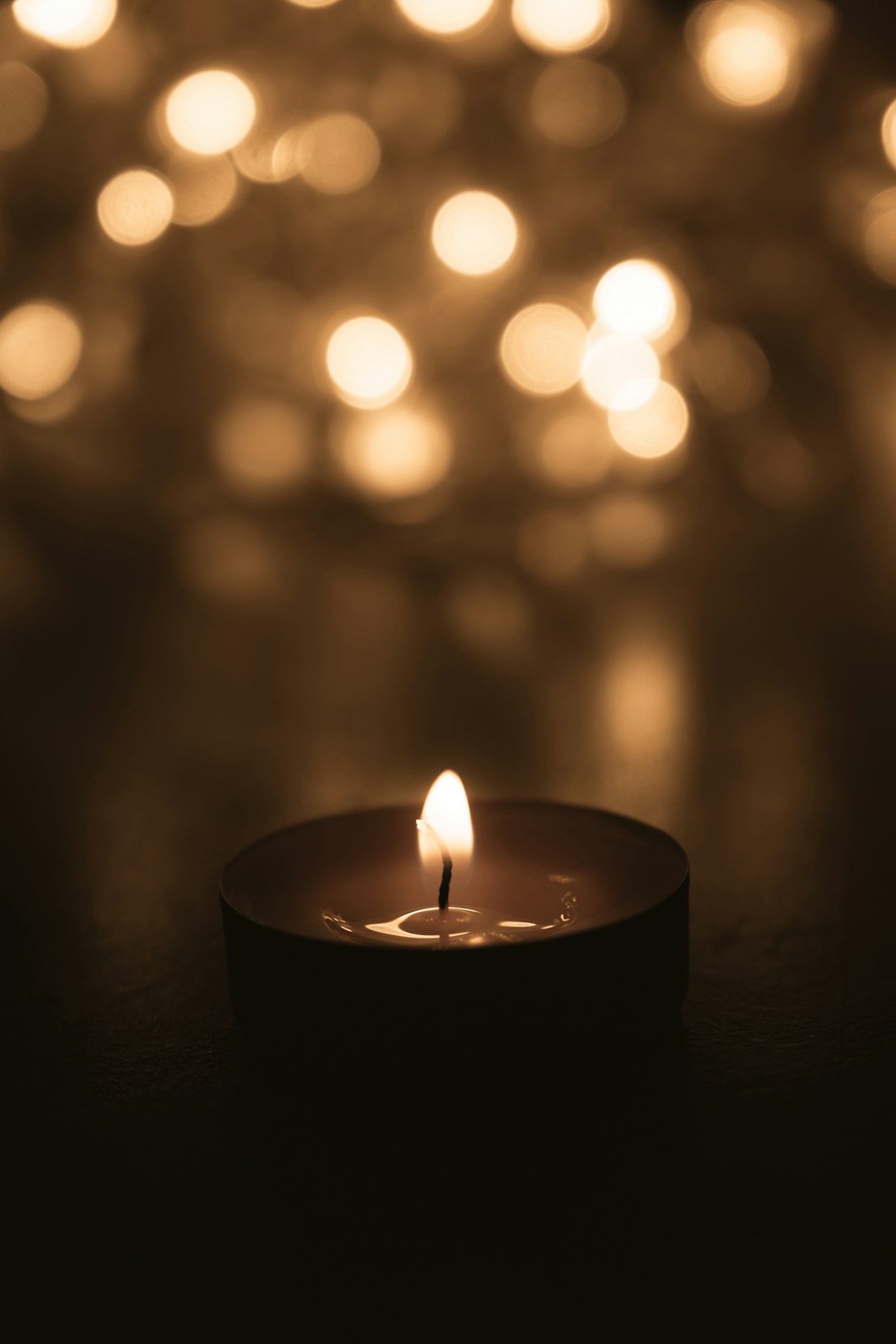 Warm candlelight surrounded by softly glowing lights