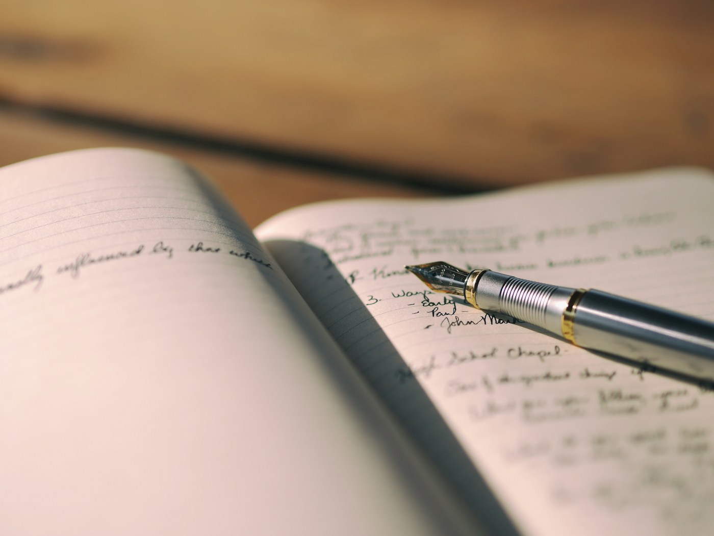 A fountain pen resting on a handwritten journal