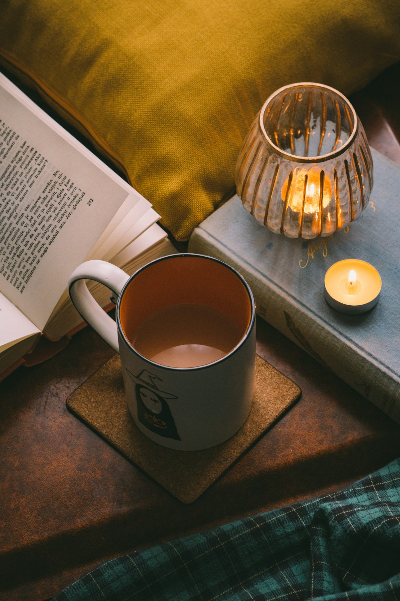 An open book and lemon tea beside candlelight